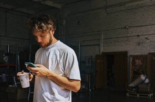 A man standing looking at his cellphone