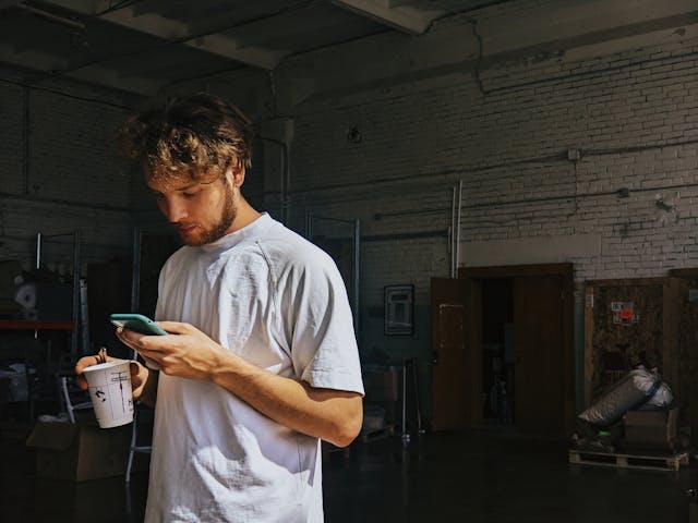 A man standing looking at his cellphone